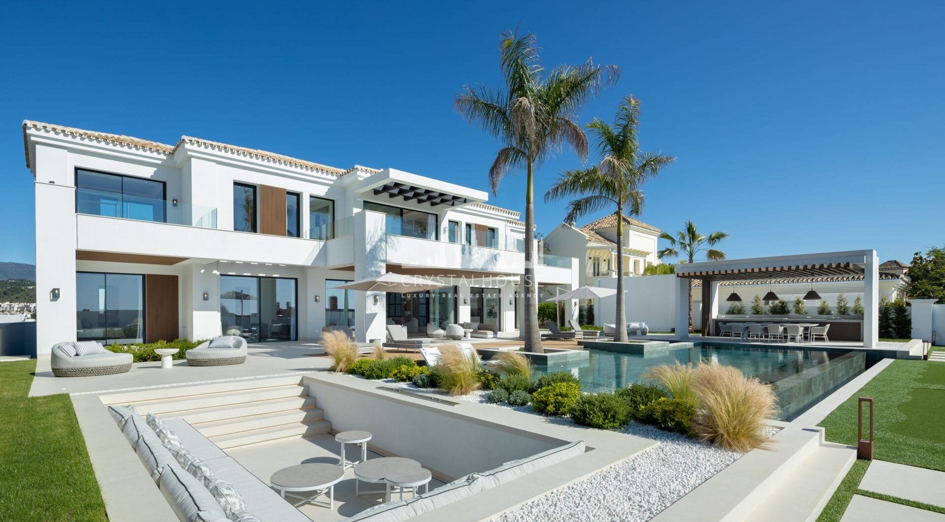 Luxury villa with panoramic sea and mountain views in the exclusive Monte Halcones, La Quinta. 7 en-suite bedrooms, 803 m² built, 2,042 m² plot. Fully equipped spa, gym, cinema, and multiple terraces. Price: €9.600.000.