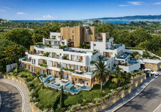 Modern residential building at Royal River Marbella with terraces, private pools, lush greenery and sea views.